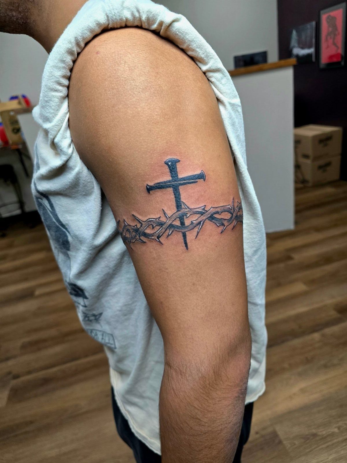 Cross tattoo with a crown of thorns on a man's upper arm