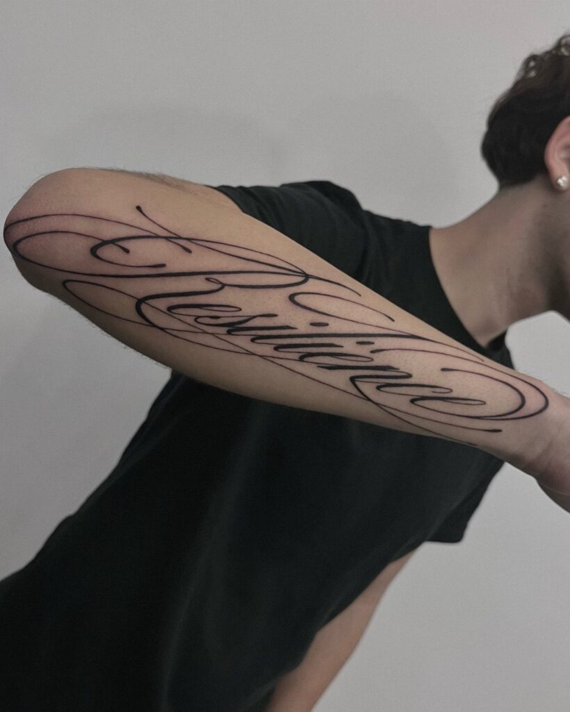 Cursive lettering tattoo of the word Resilience on a person's forearm