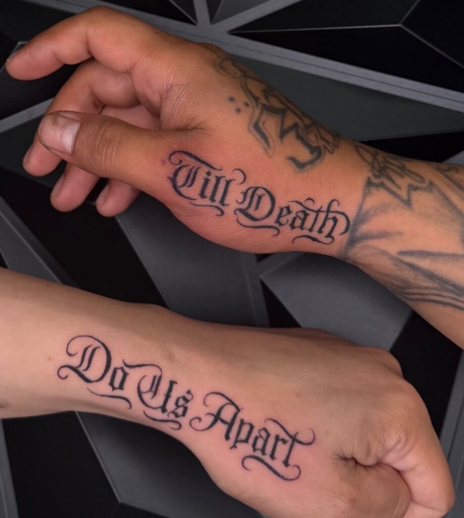 Two hands featuring gothic black ink tattoos that read Till Death Do Us Apart