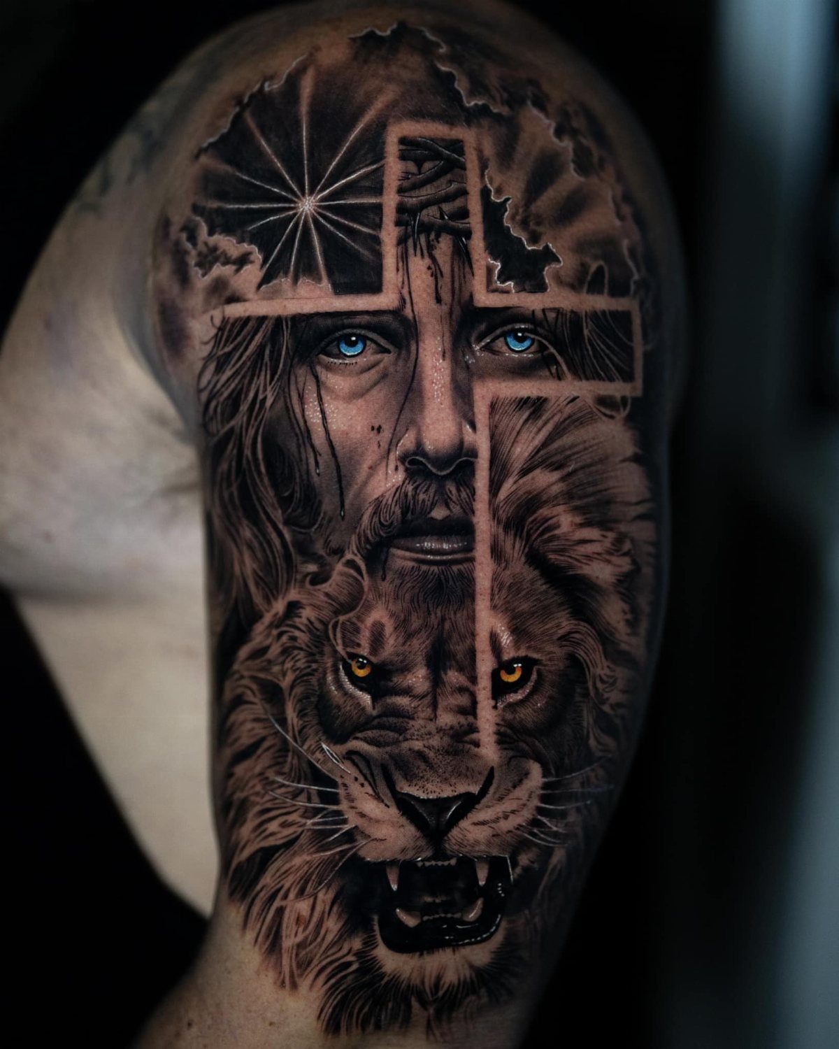 Detailed arm tattoo showing a split face of Jesus and a lion with a cross.