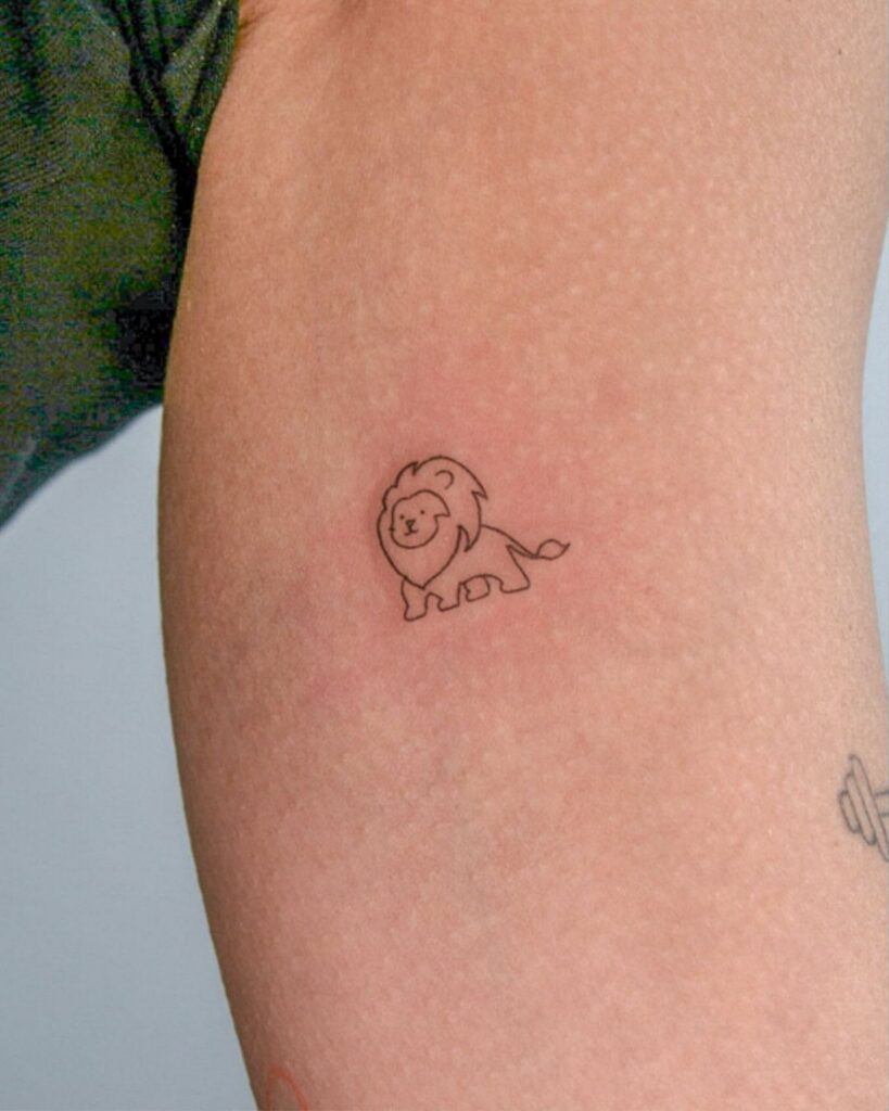 Small minimalist lion line drawing tattoo on a person's arm.