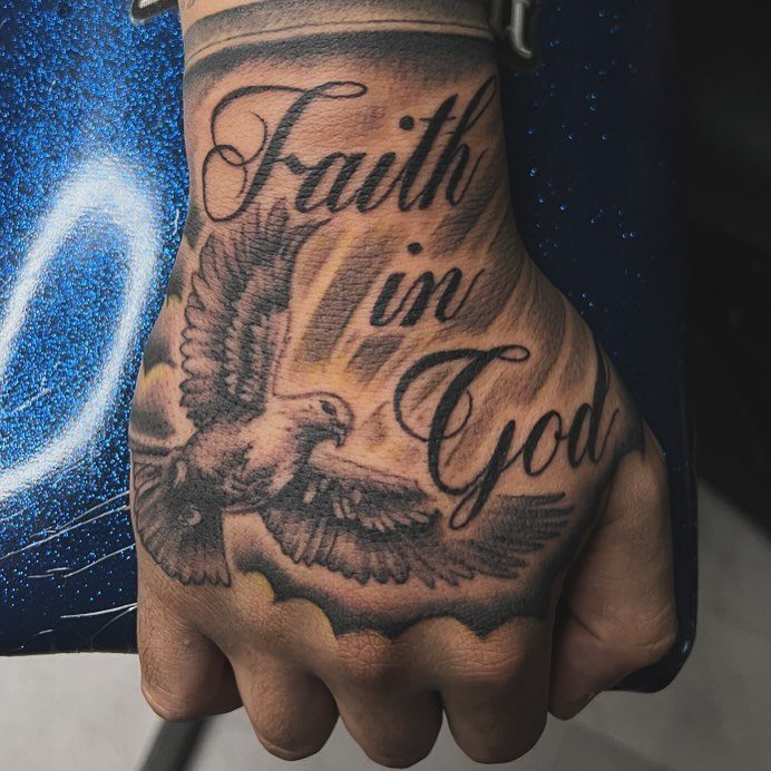 Hand tattoo featuring a flying dove and the words Faith in God