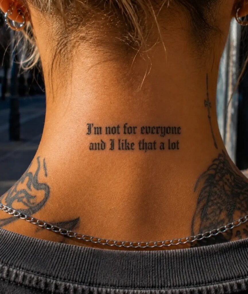 Gothic word tattoo on the back of a woman's neck reading I'm not for everyone