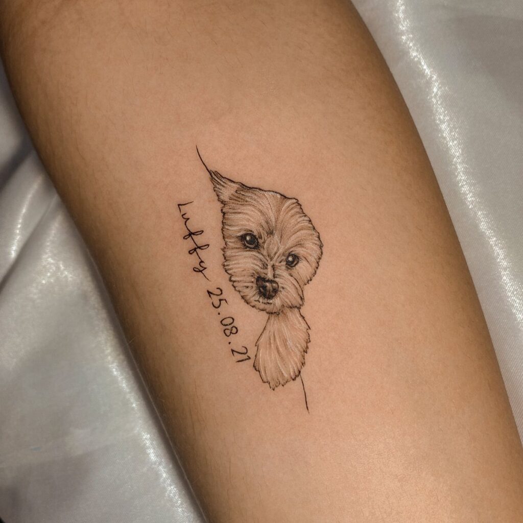 Realistic dog portrait tattoo with name and date on a person's forearm